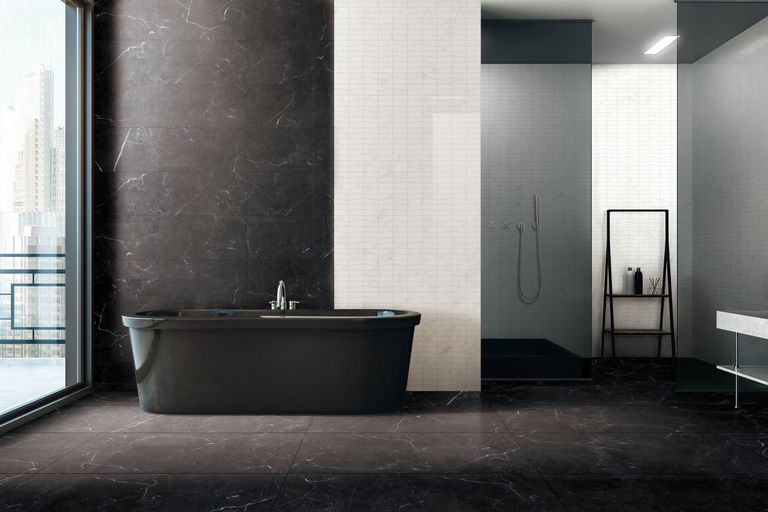 Sophisticated interior of a modern bathroom featuring a sleek black bathtub and marble tiles.